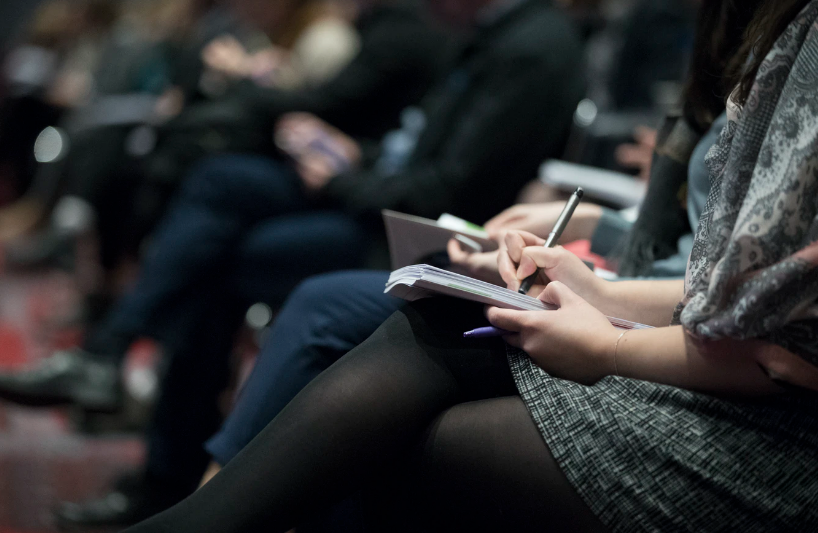 People taking notes at an event