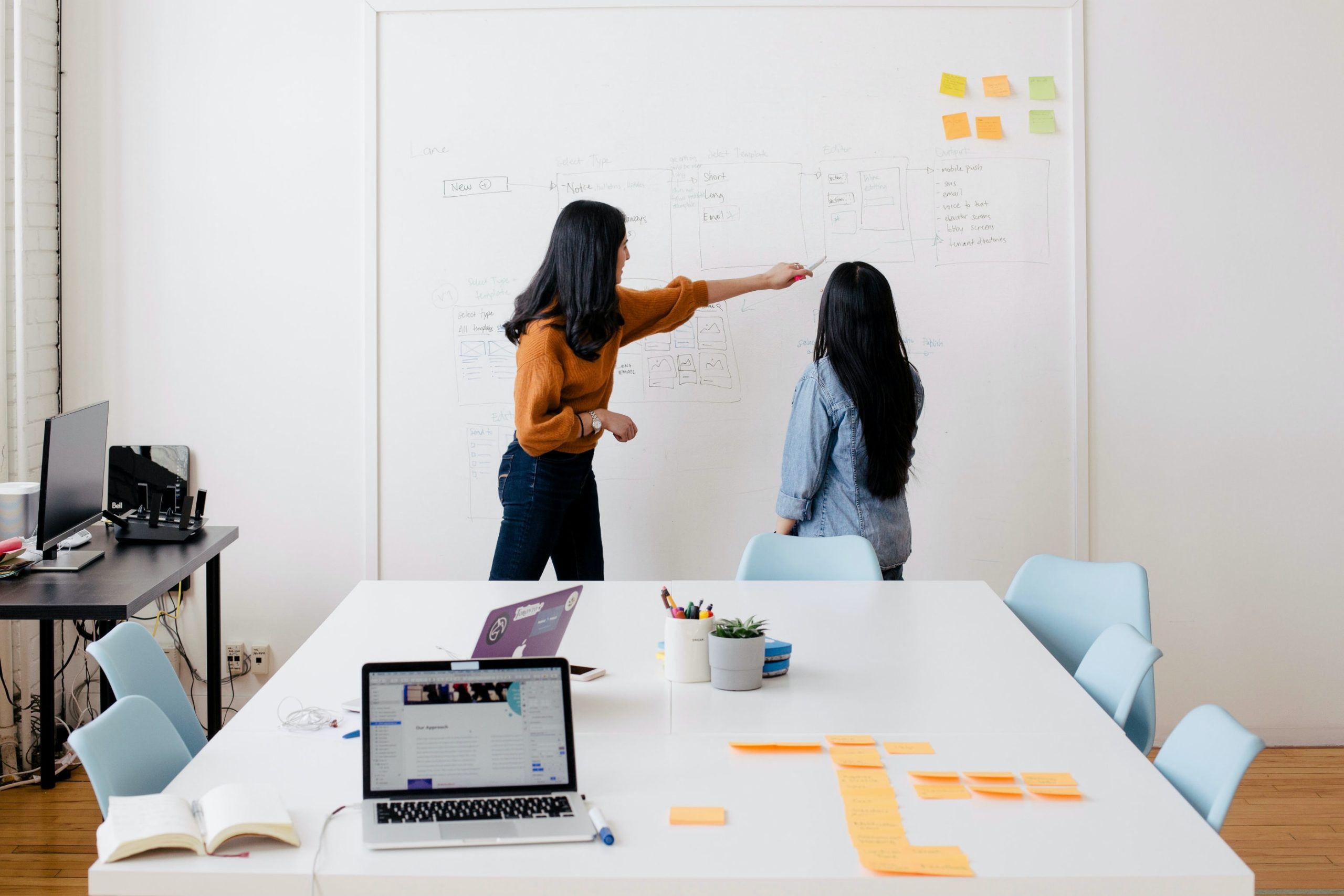 woman in brown long-sleeved shirt in front of dry erase board