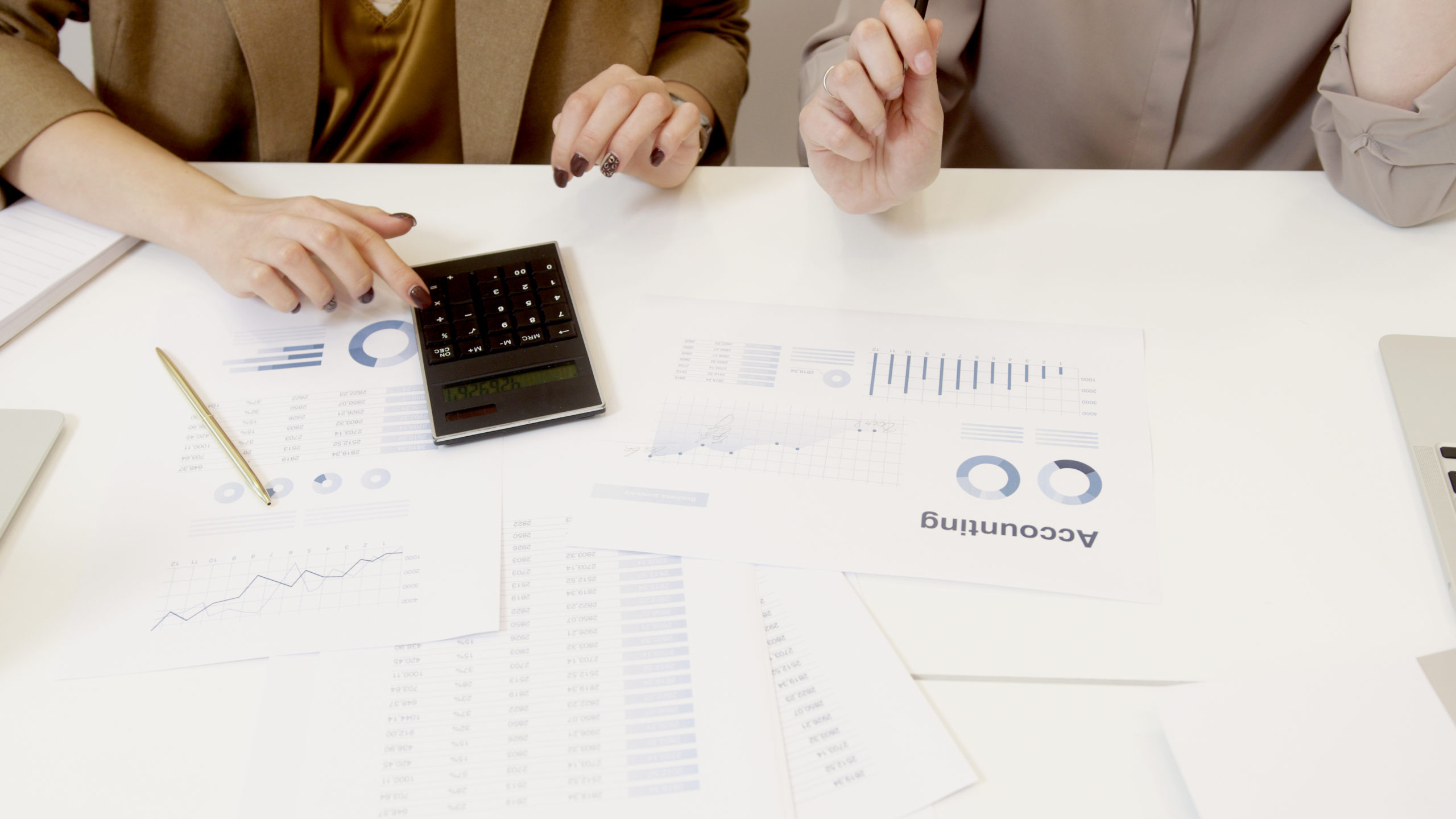 Two women working with accounting data on table