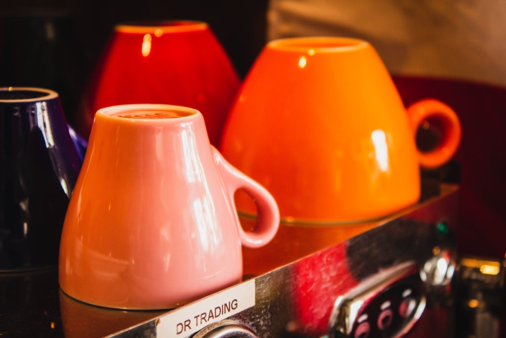four orange and black ceramic mugs